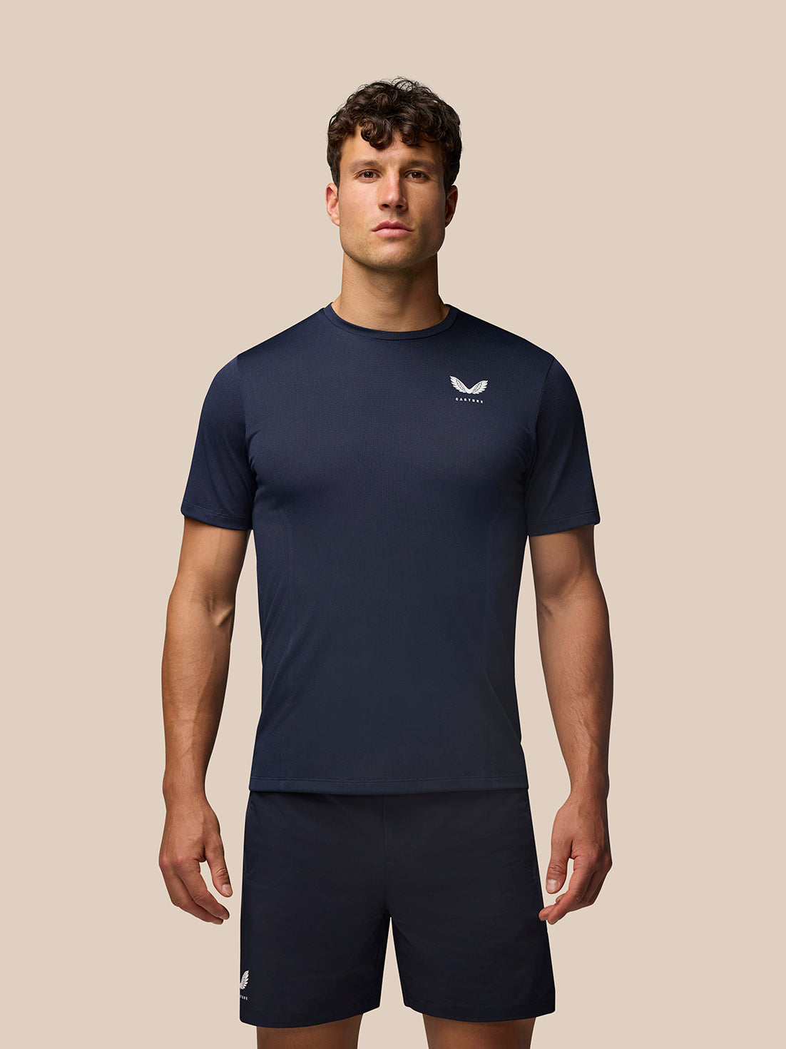 Male model wearing midnight navy Apex Training T-Shirt with crew neck raglan sleeves and Castore branding on the chest