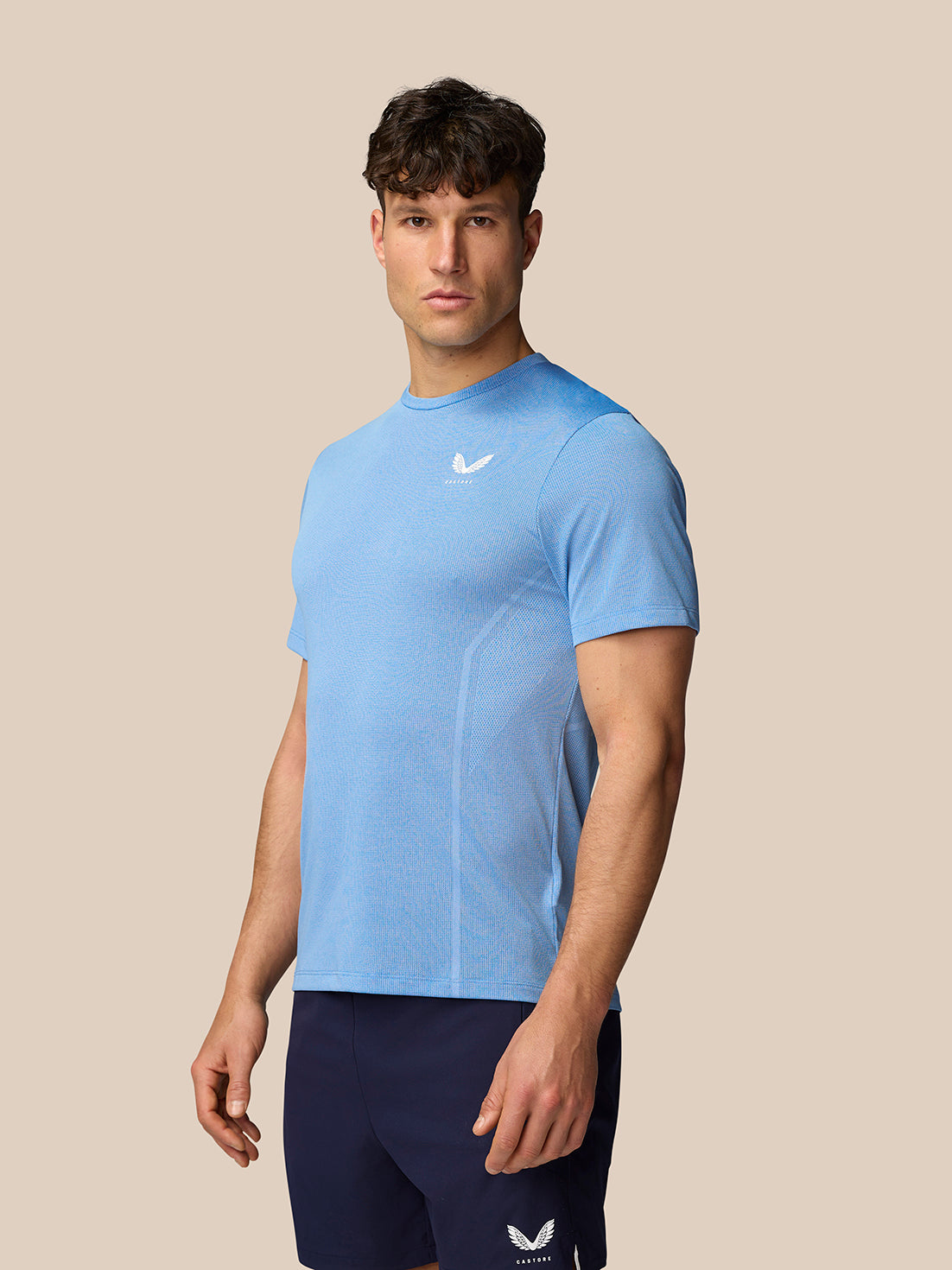 Male model wearing sky blue Apex Training T-Shirt featuring breathable knit fabric.