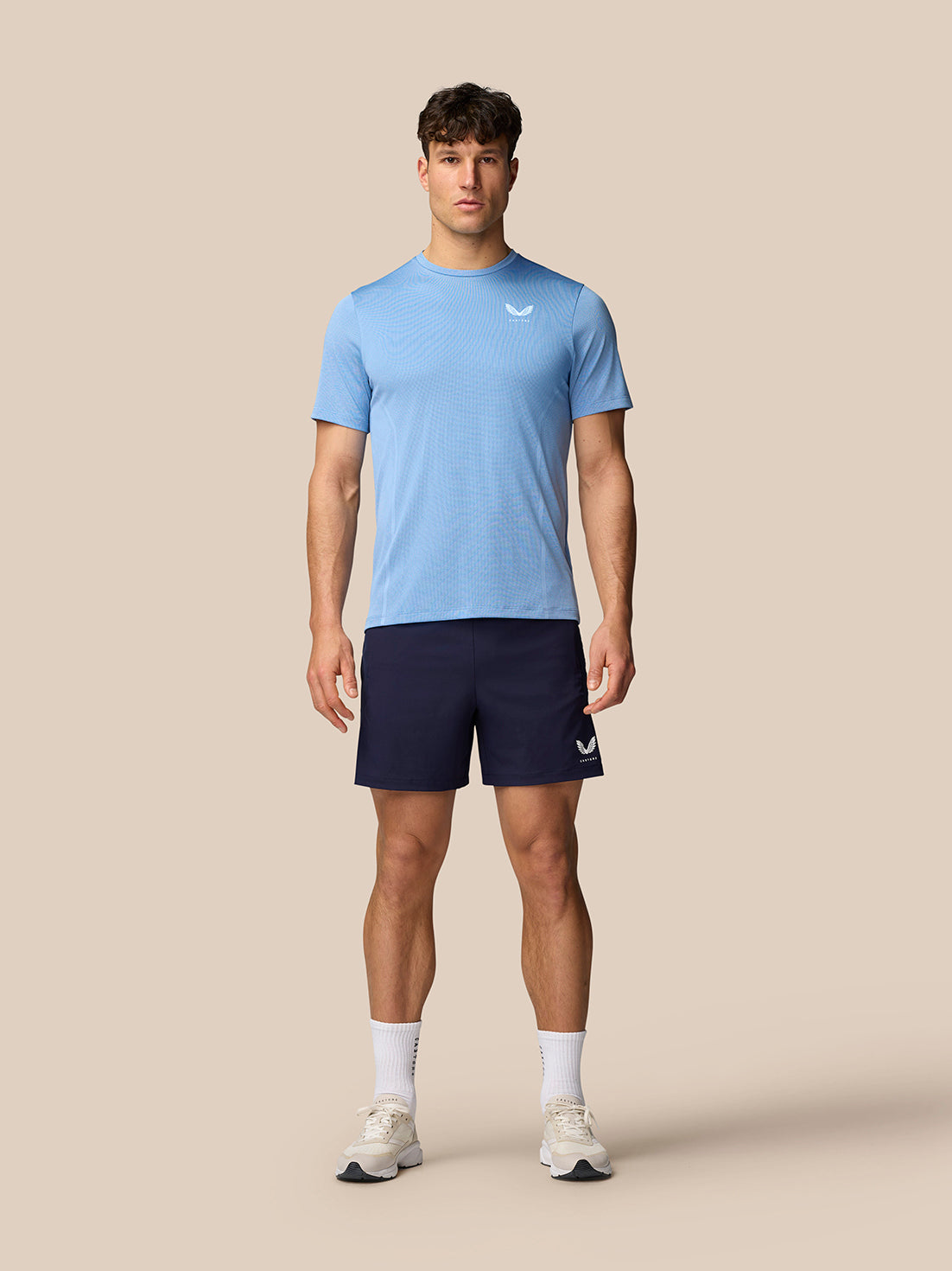 Full-length shot of man in sky blue Apex Training T-Shirt with navy shorts.