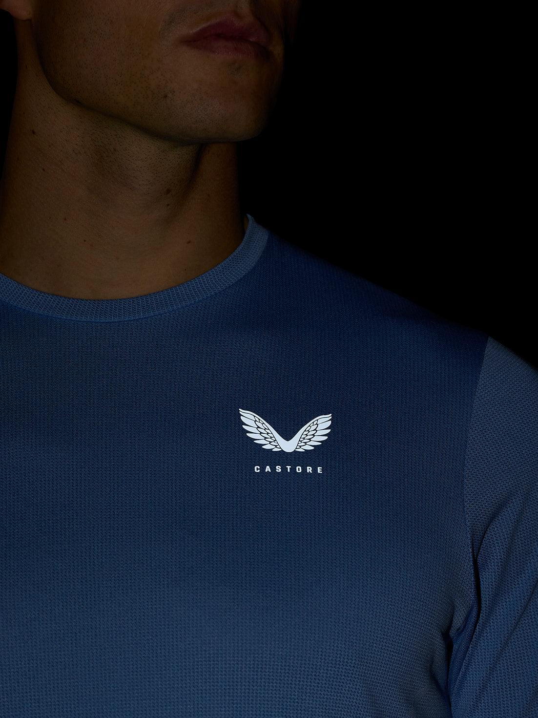 Close-up of blue Apex Training T-Shirt showing white crest logo on chest.