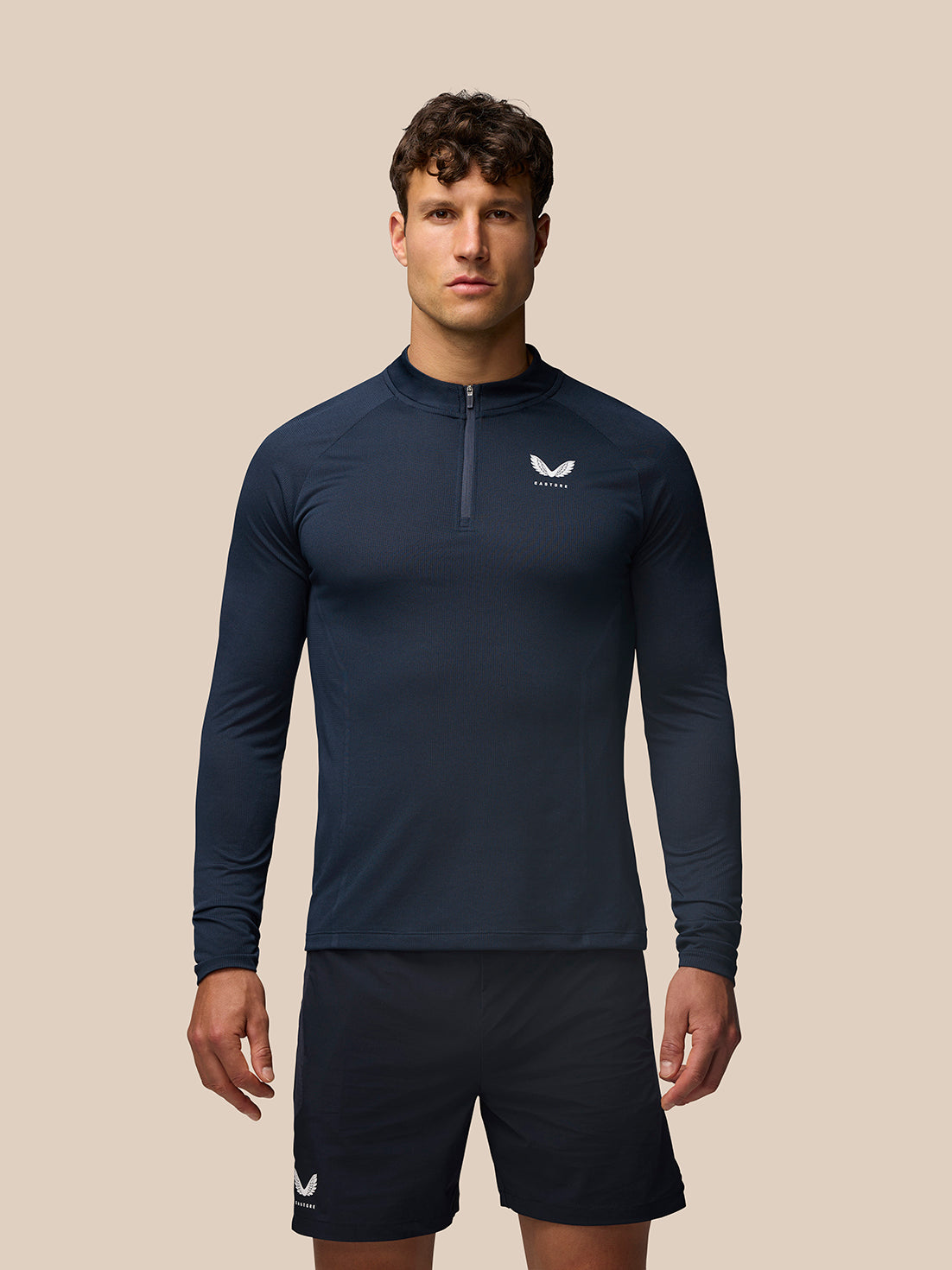 Male model in navy Apex Training 1/4 Zip Top with stand collar and Castore logo on chest