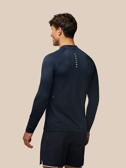 Back view of midnight navy Apex Training long sleeve knit top with vertical Castore branding down the back.
