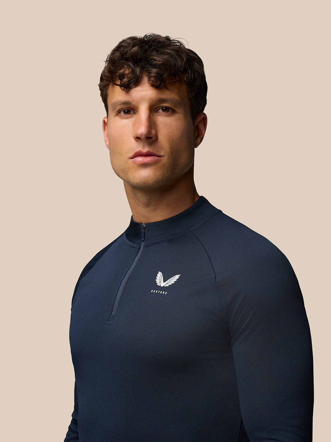 Angled front view of navy Apex Training 1/4 Zip Top on a model highlighting the zip and Castore logo on the left chest.