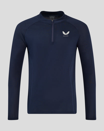 Male model wearing midnight navy Apex Training long sleeve quarter zip top with stand collar and chest logo, paired with navy shorts
