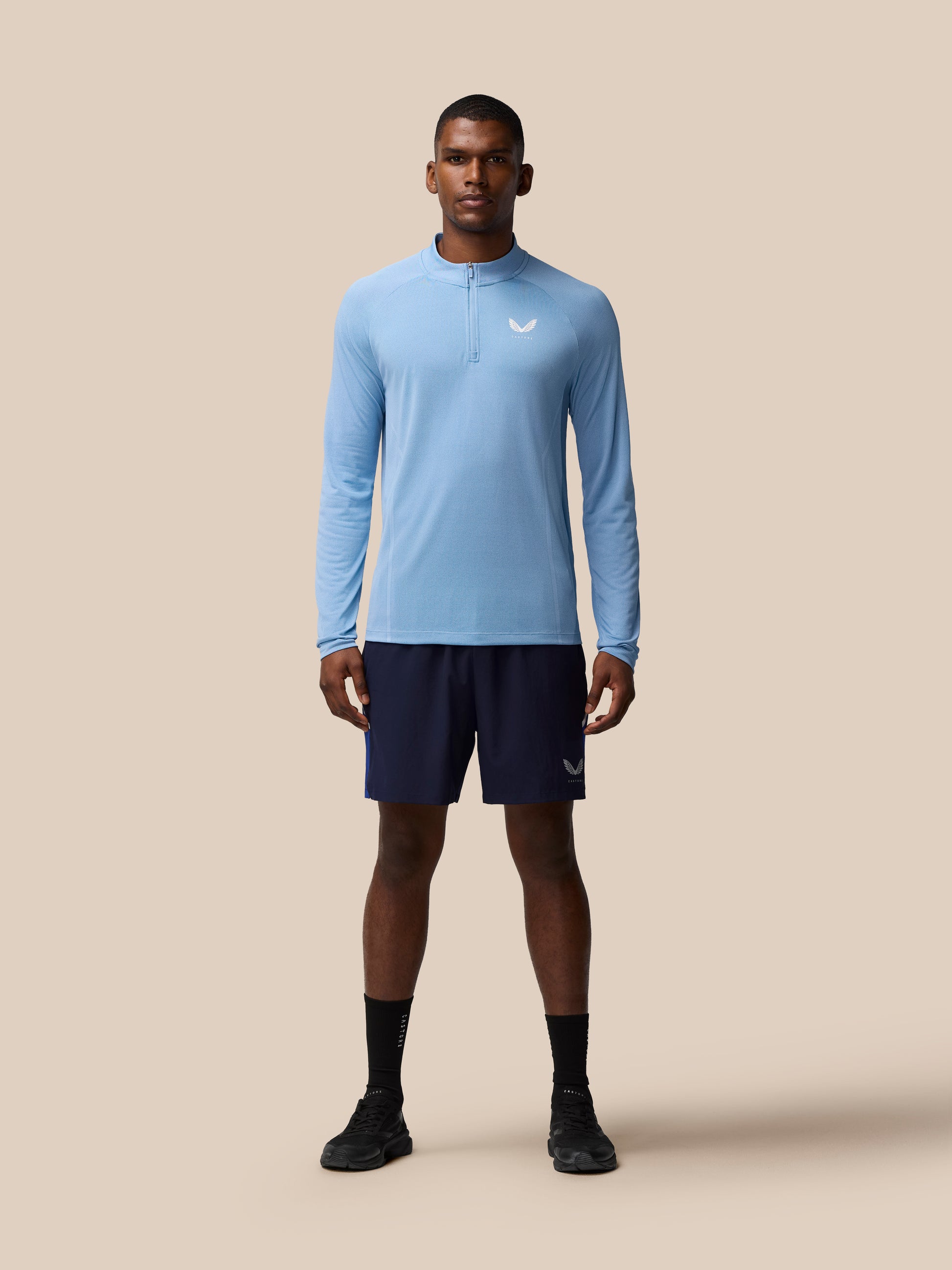 Front view of a man wearing sky blue Apex Training 1/4 Zip Top with a white logo on the chest.
