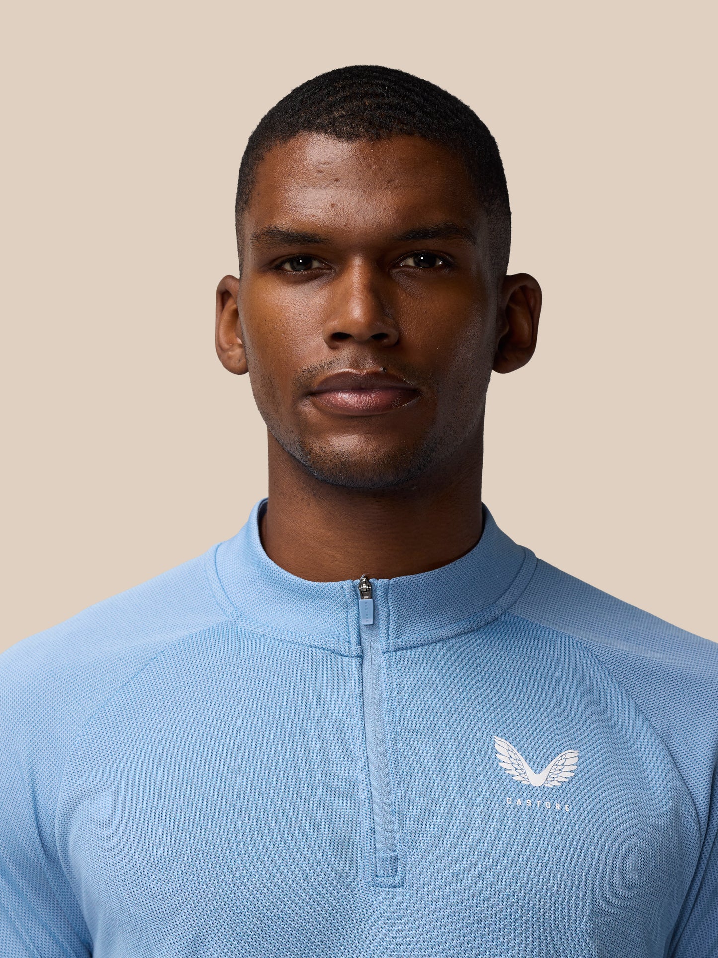 Close up of the chest area on the sky blue Apex Training 1/4 Zip Top showing the zipper and logo.