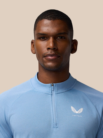 Close up of the chest area on the sky blue Apex Training 1/4 Zip Top showing the zipper and logo.
