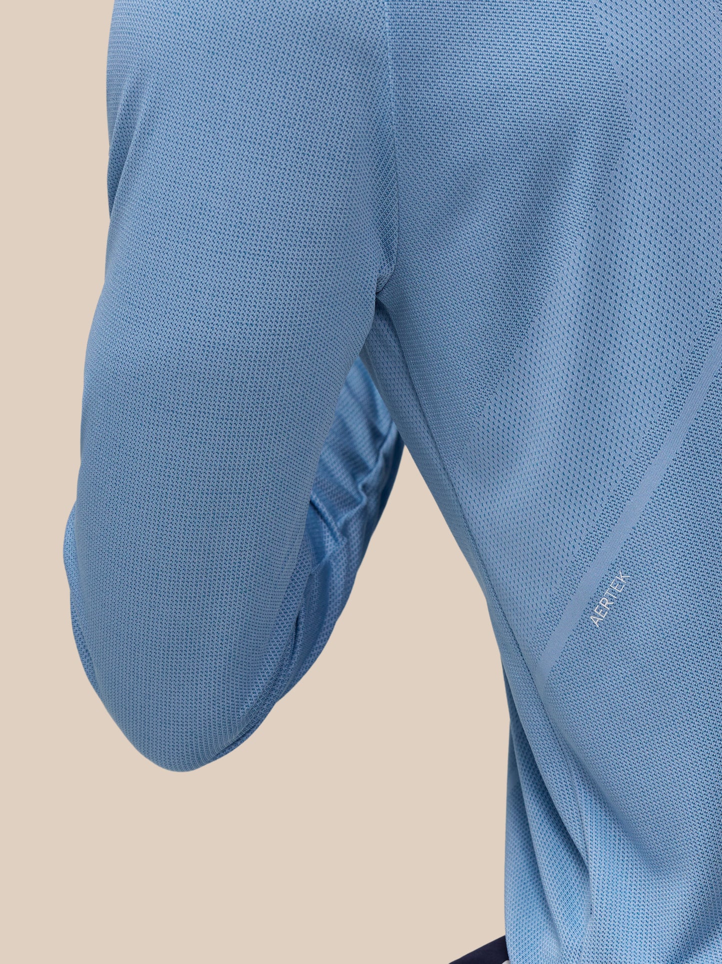 Close-up of sky blue Apex Training top fabric with breathable mesh knit and branding along the sleeve
