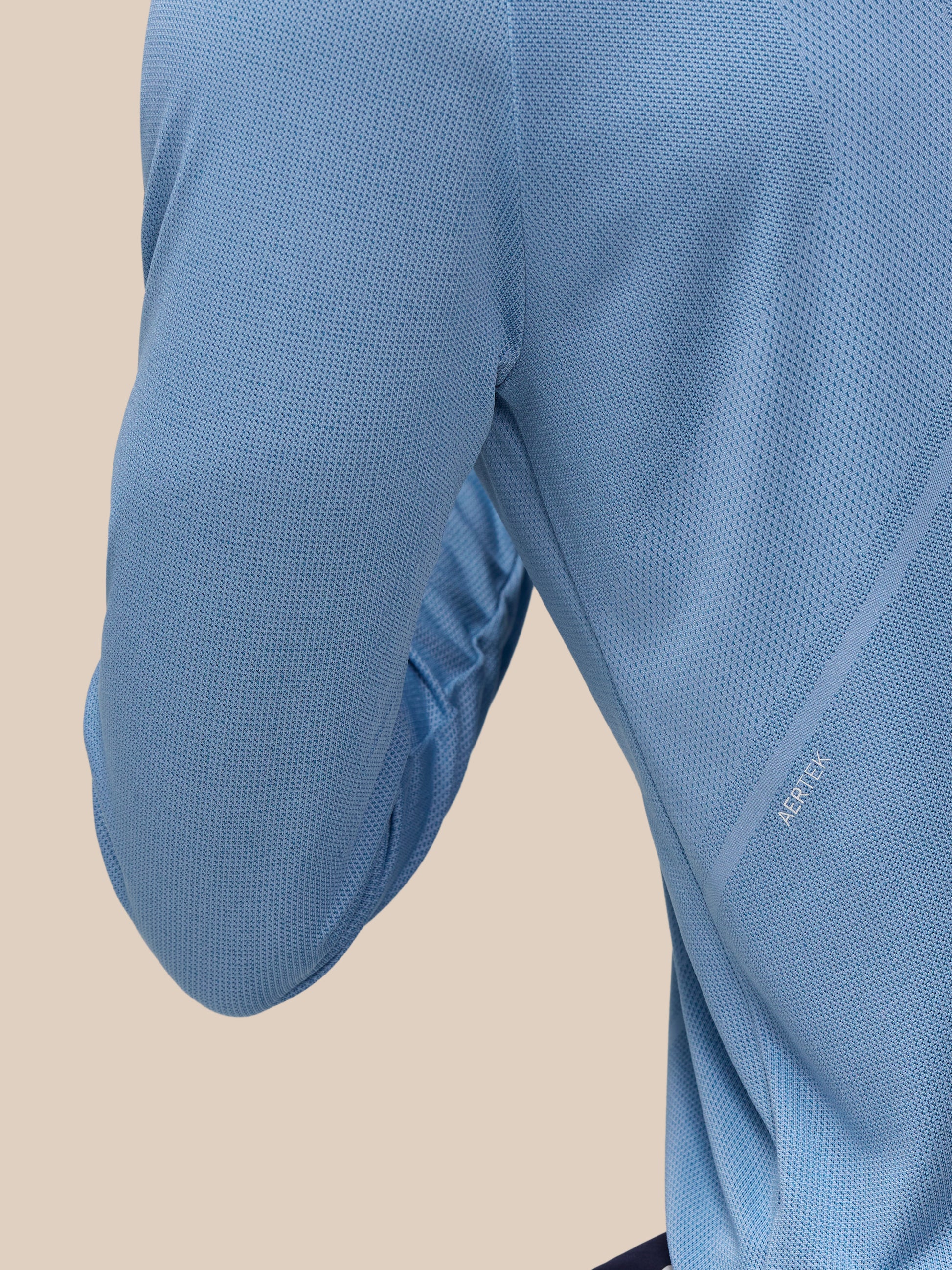 Close-up of sky blue Apex Training top fabric with breathable mesh knit and branding along the sleeve