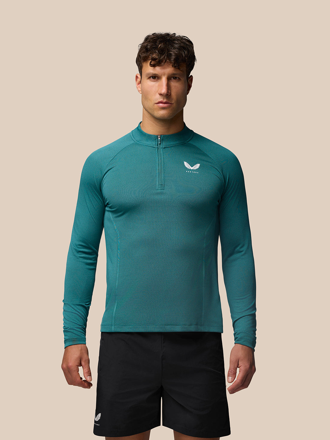 Teal Apex Training long sleeve 1/4 Zip Top worn by a model with center front zipper and Castore logo on the left chest
