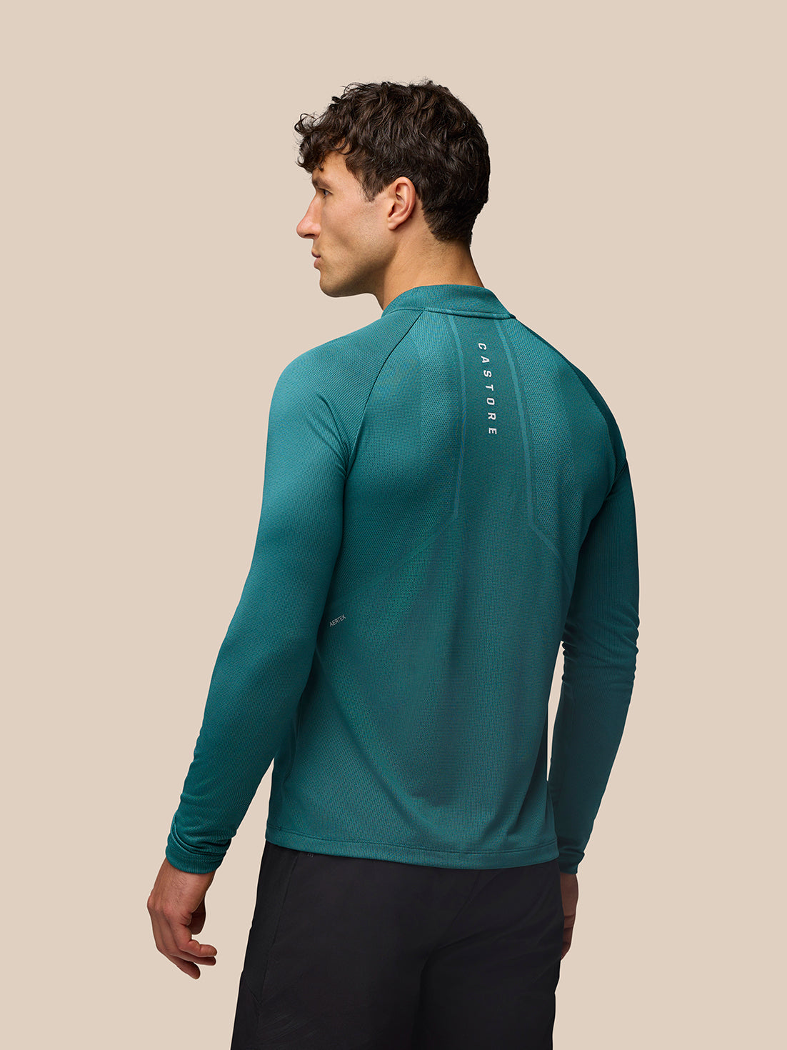 Back view of teal Apex Training top with reflective Castore branding along the upper back