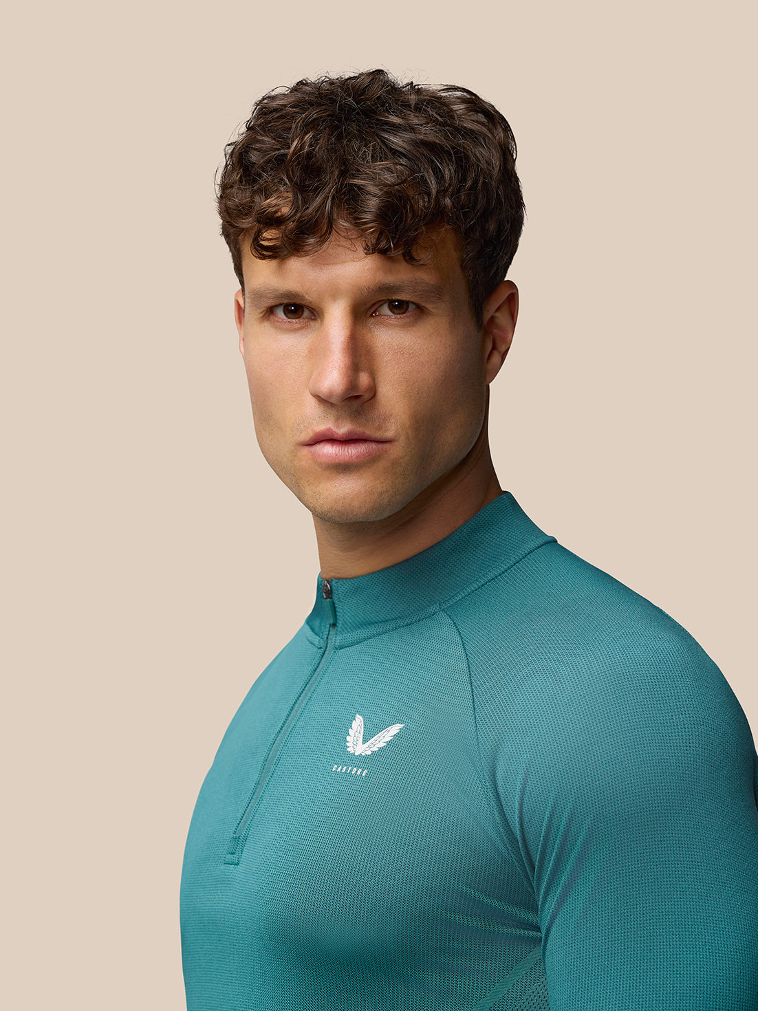 Teal Apex Training top shown from a side back angle highlighting textured knit fabric and a high neck with zip