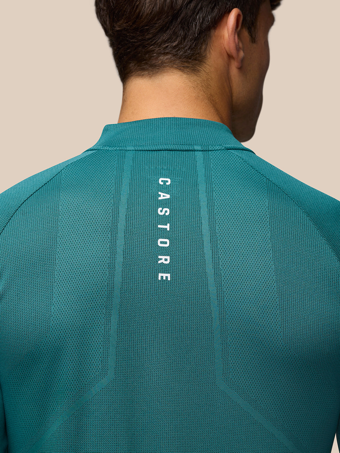 Back view close up of teal training top showing vertical AERTEK branding on the back