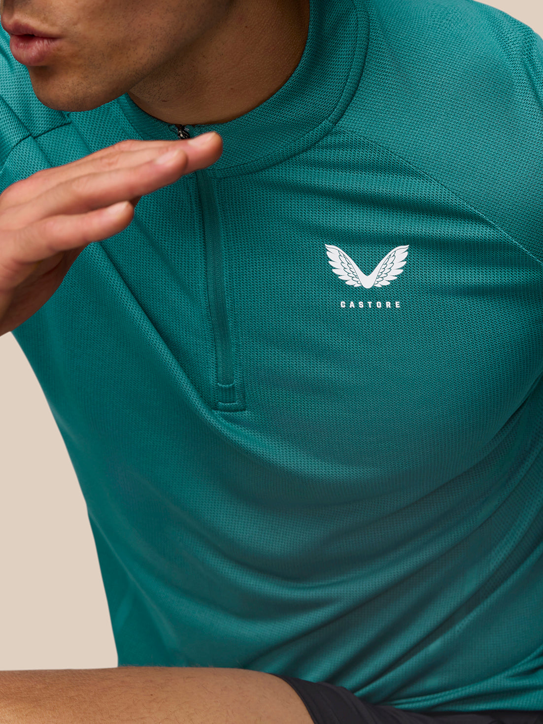 Close up of aqua Apex Training 1/4 Zip Top showing front zipper and Castore logo on the left chest.