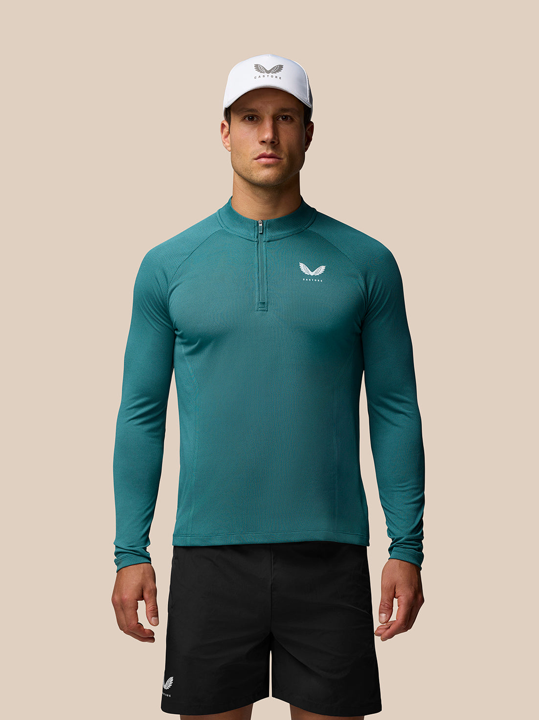 Male model wearing teal Apex training long sleeve quarter zip top with front zipper and chest logo