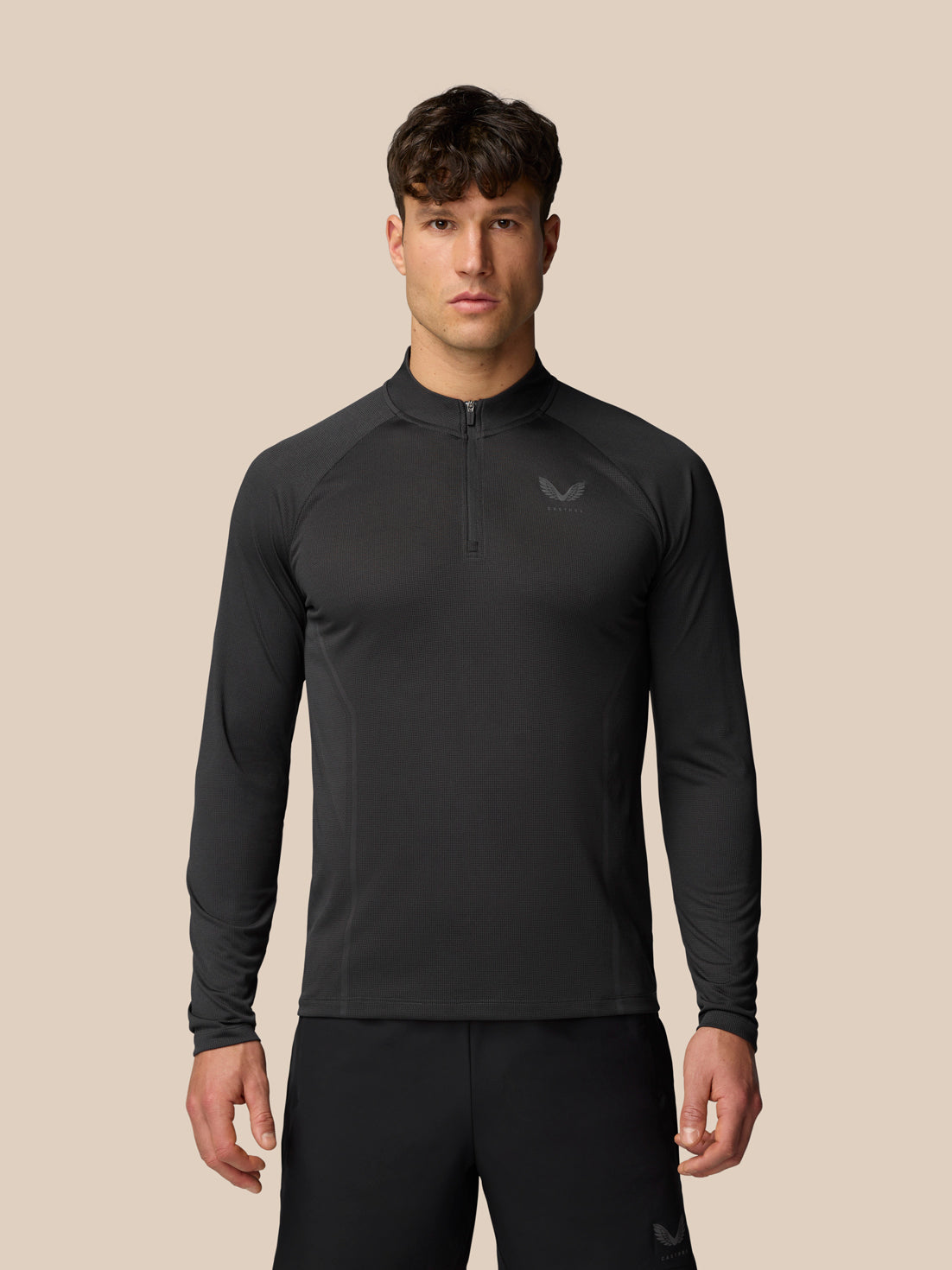 Male model wearing Apex Training 1/4 Zip Top in black gunmetal, front view with center zip and athletic knit
