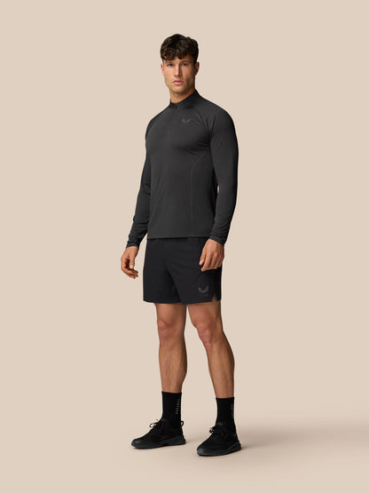 Male model in dark Apex Training long sleeve 1/4 zip top with logo on the chest