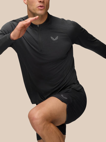 Front view of a man in black gunmetal Apex Training 1/4 Zip Top with short zip and Castore wing logo on the chest