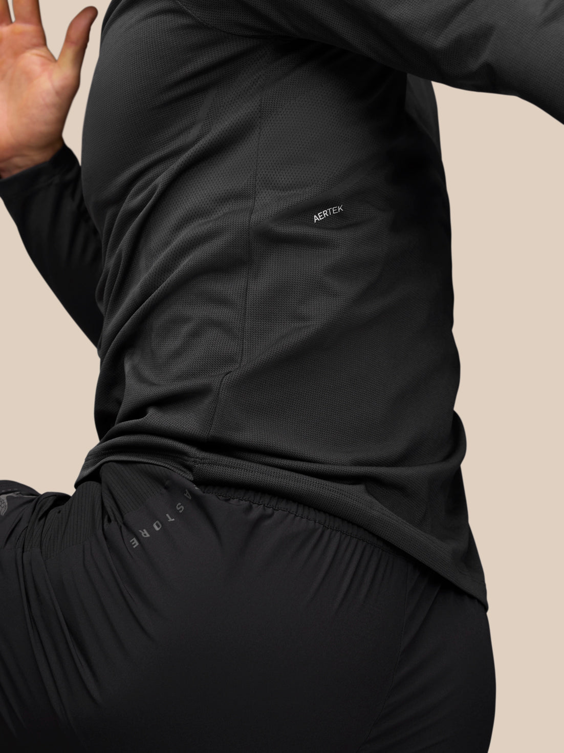 Side view of a man wearing Apex Training 1/4 Zip Top in black gunmetal highlighting AerTek sweat-wicking and mesh panels