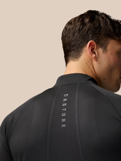 Back view of a man in black gunmetal Apex Training 1/4 Zip Top with mesh panels and Castore branding along back