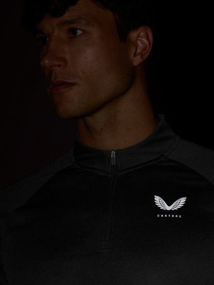 Male model wearing black Apex Training 1/4 zip top with front zipper and Castore logo on the chest