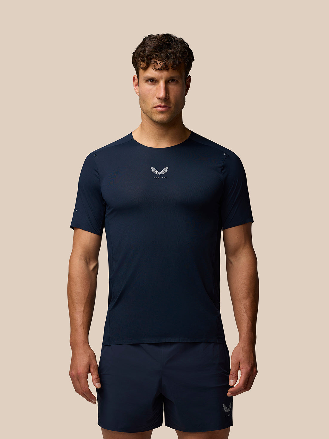 Zone Training T Shirt in navy on a model showing athletic fit crew neckline halo eyelets and reflective Castore branding on chest