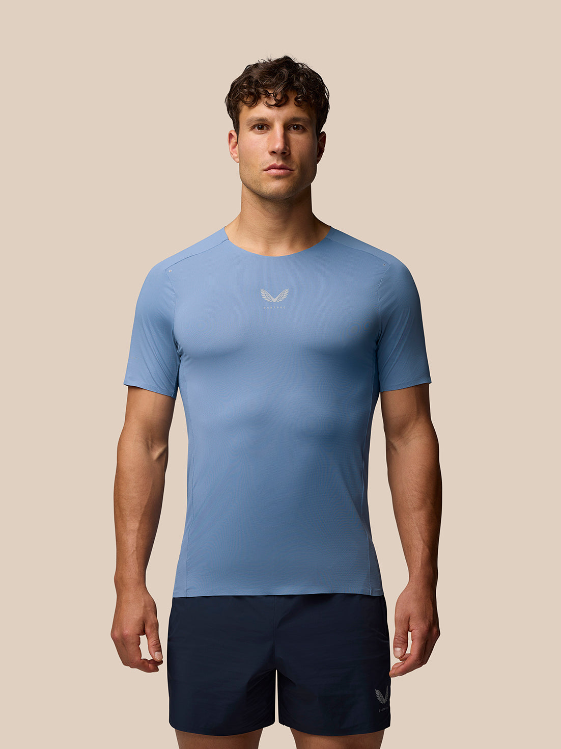 Male model wearing blue Zone Training T-Shirt in athletic fit with reflective branding on chest and cuff
