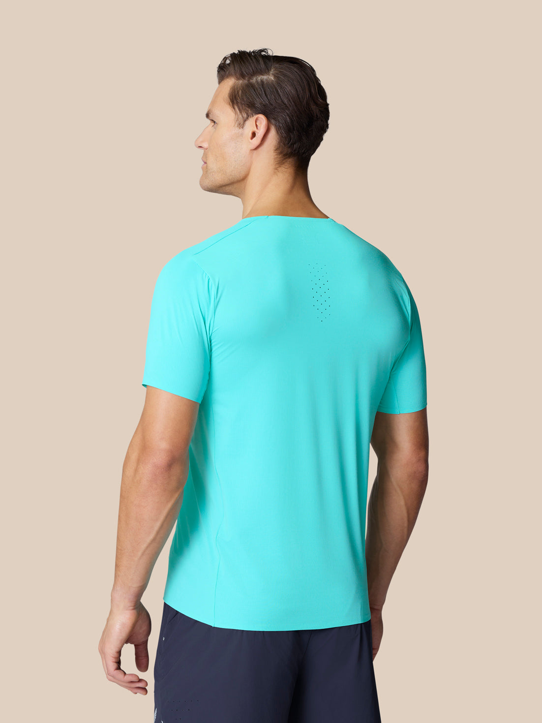 Back view of a man wearing Zone Training T-Shirt in Light Aqua, highlighting subtle back ventilation perforations.