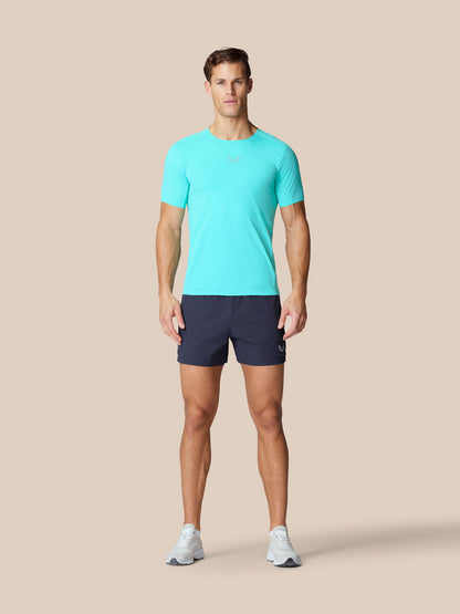 Full-body view of a model wearing light aqua Zone Training T Shirt with navy shorts