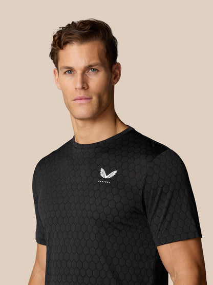 Front view of male model in Flow Training T-Shirt Black with honeycomb knit and white Castore crest on the chest.