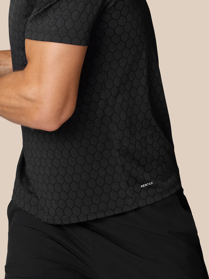 Side back view of black Flow Training T Shirt showing honeycomb knit with AERTEK branding at the lower hem