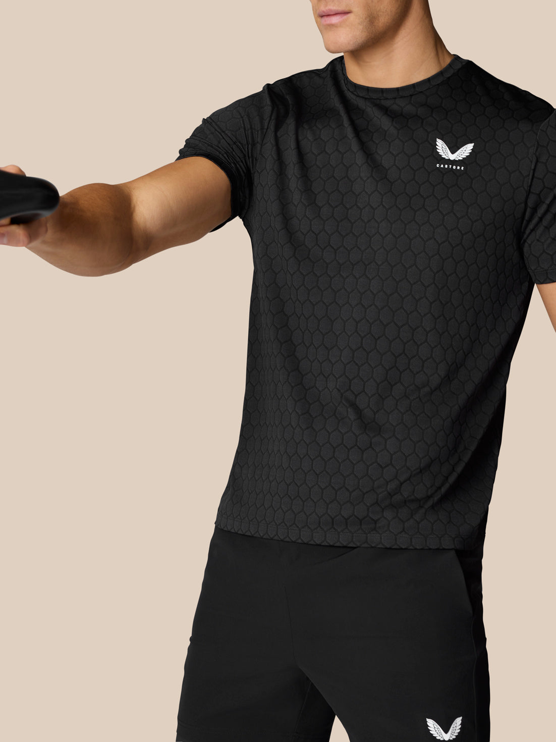 Front view of man wearing Flow Training T Shirt with hexagonal pattern and white Castore crest on chest