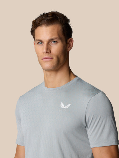 Male model wearing Flow Training T-Shirt Grey with honeycomb pattern and Castore logo on the chest