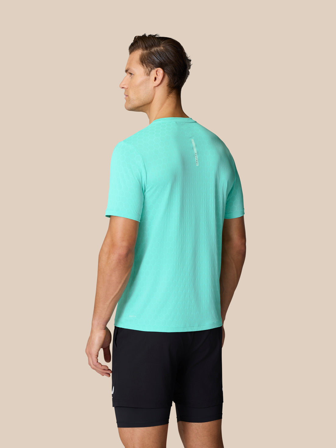 Back view of male model in turquoise Flow Training T Shirt featuring honeycomb pattern