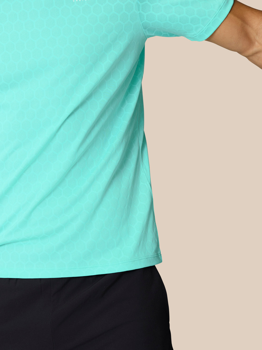 Side view of a man in Flow Training T-Shirt Light Aqua showing the honeycomb knit texture