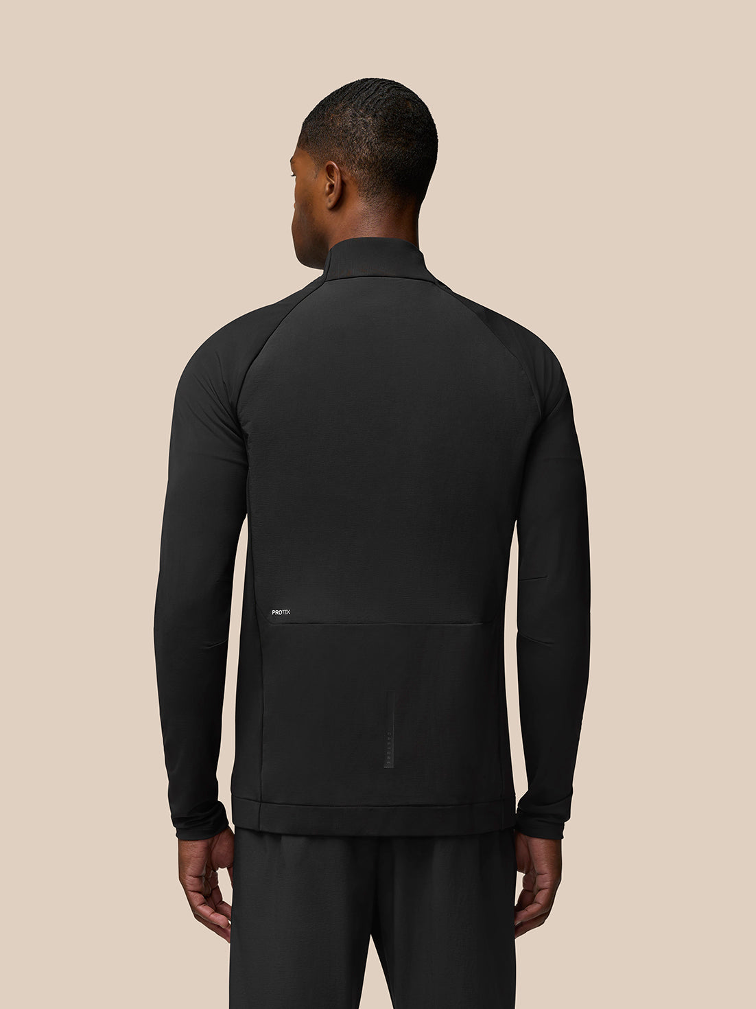 Back view of Flow Training Jacket in black on a male model with a high collar