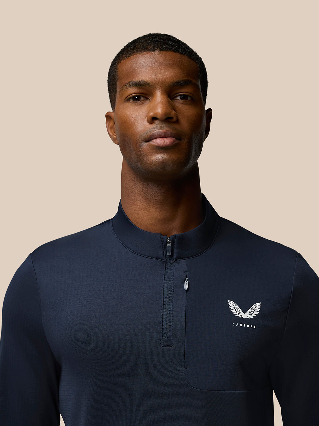 Close up of navy Flow Quarter Zip Sweater Top chest area showing funnel collar zipper and Castore logo