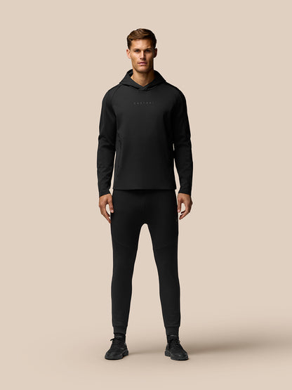 Man wearing Garcia Water Resistant Hoodie in black with Castore chest logo and zipped side pockets.