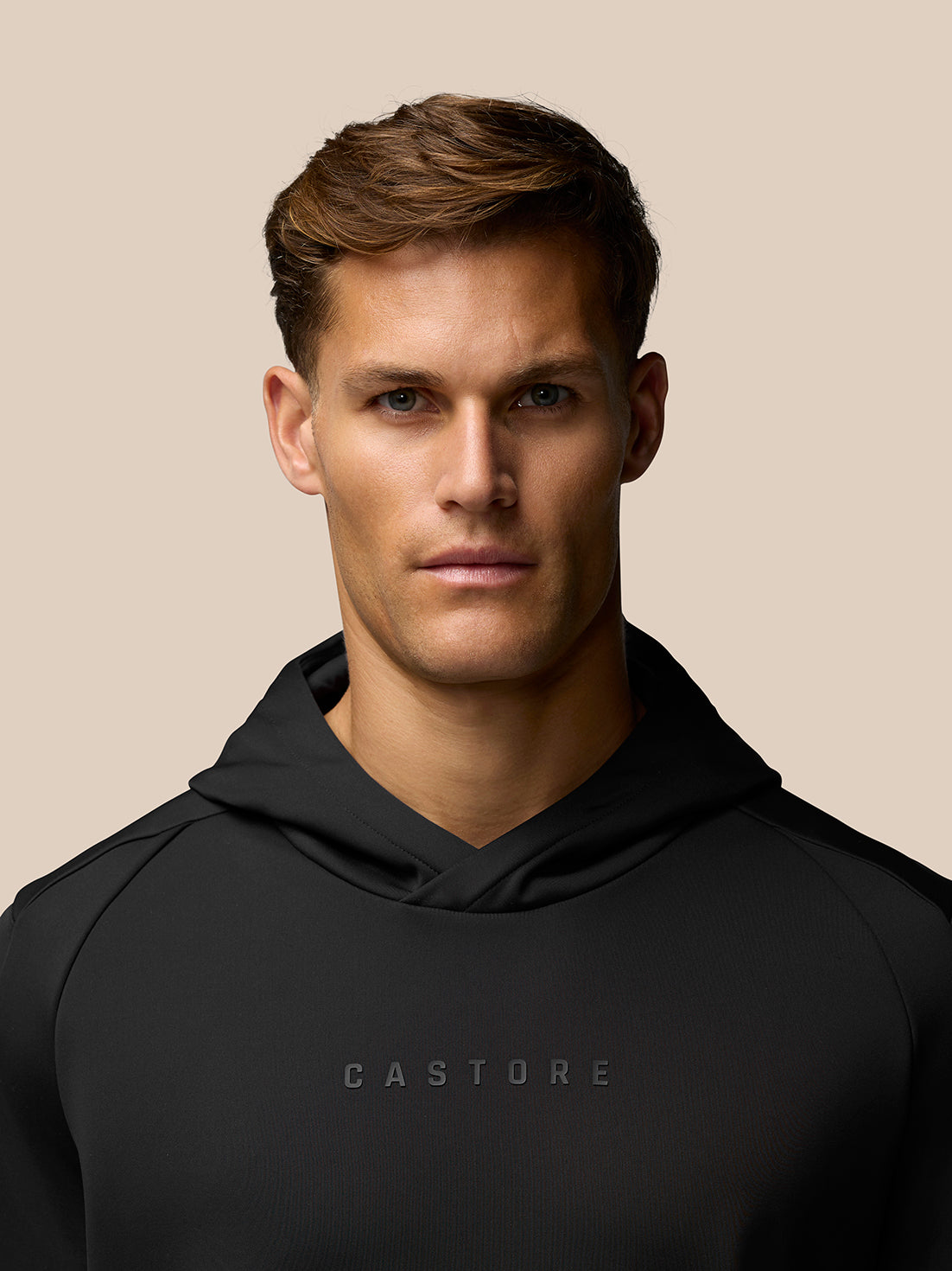 Close up of a man in a black Garcia hoodie with CASTORE branding across the chest.