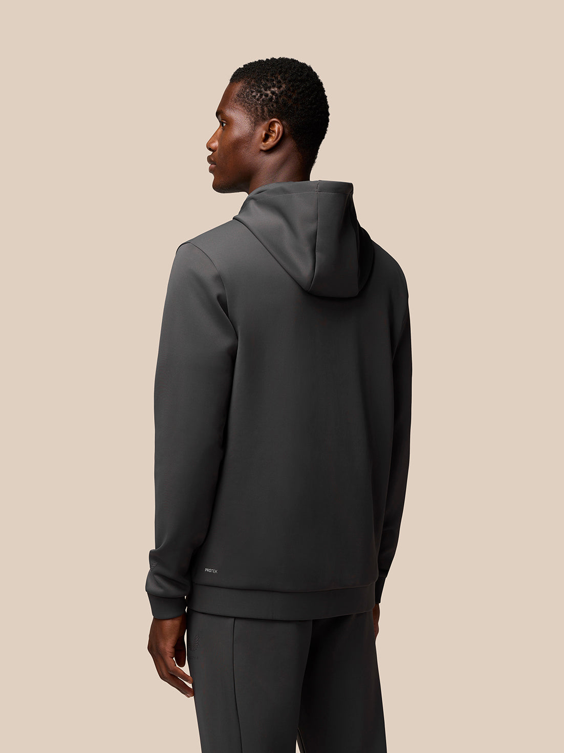 Back view of a charcoal Flex Lifestyle Full Zip jacket worn by a model with the hood up.
