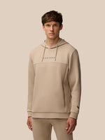 Male model wearing mushroom beige Flex Lifestyle Hoodie with a drawstring hood and Castore wordmark on the chest.