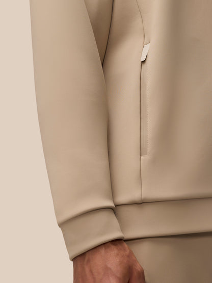 Beige Flex Lifestyle Hoodie side view highlighting a vertical zip pocket and cuff detail.