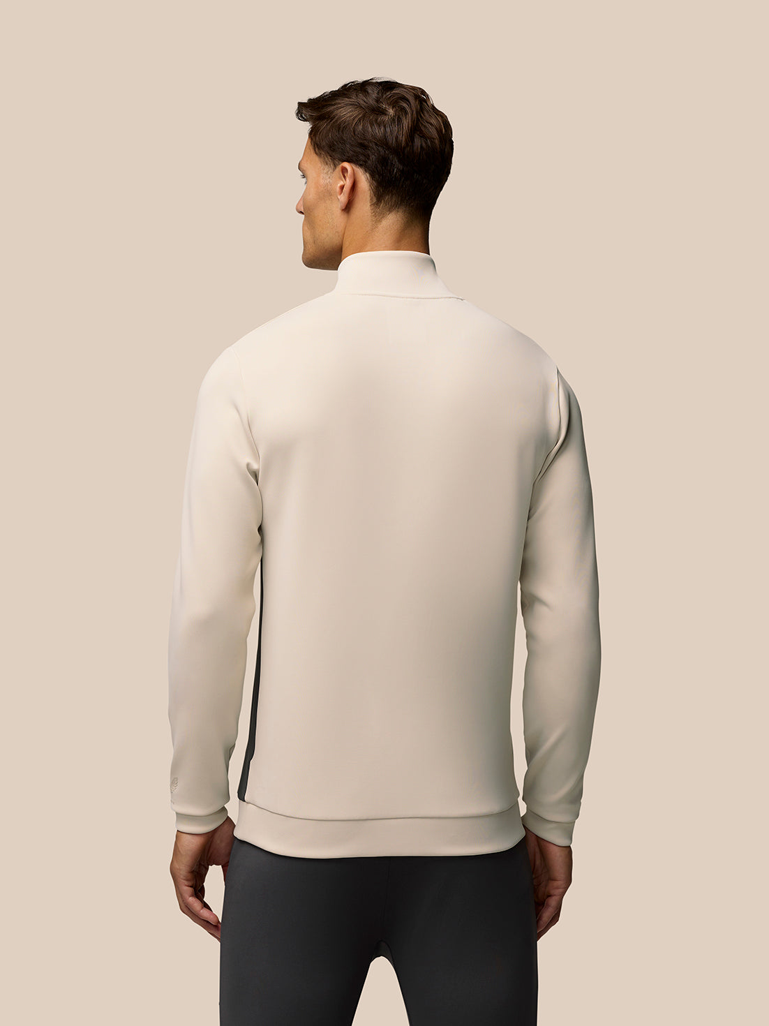 Back view of beige Flex Lifestyle 1/4 Zip top on a male model, highlighting smooth silhouette and ribbed hem.