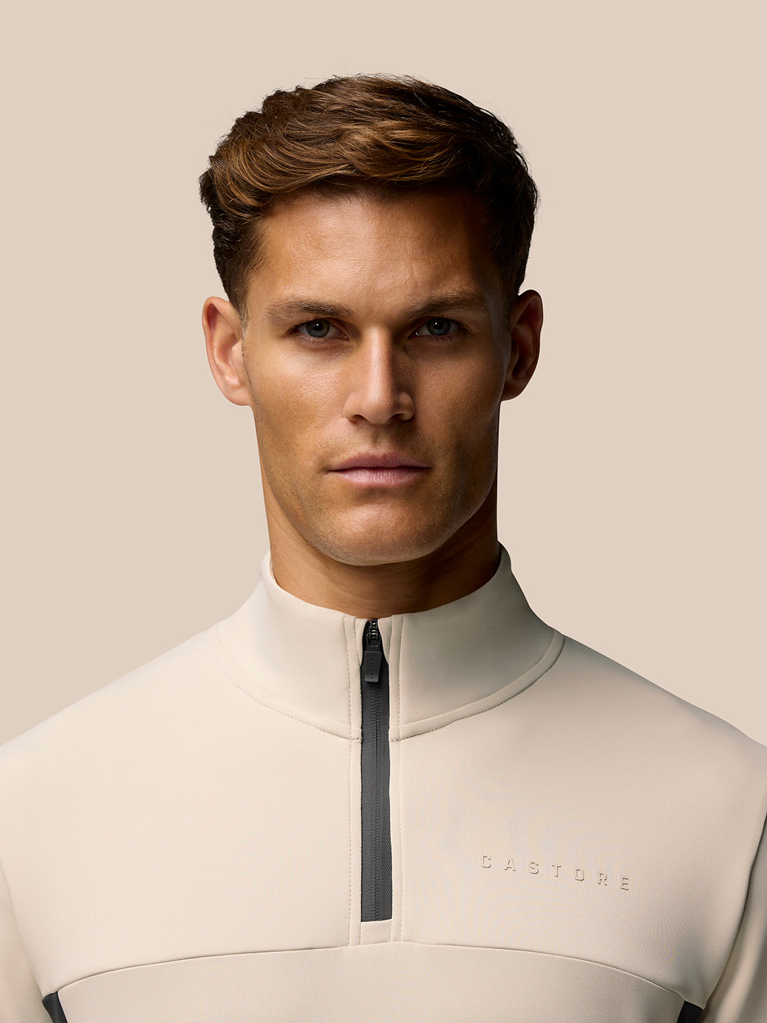 Front view of beige Flex Lifestyle 1/4 Zip top with high collar and front zip placket.