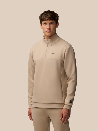 Male model wearing mushroom beige Flex Lifestyle 1/4 Zip top with centre front zip and Castore logo.