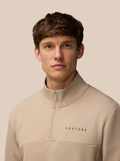 Model wearing Flex Lifestyle 1/4 Zip Mushroom Gunmetal with front zipper and Castore logo on the chest