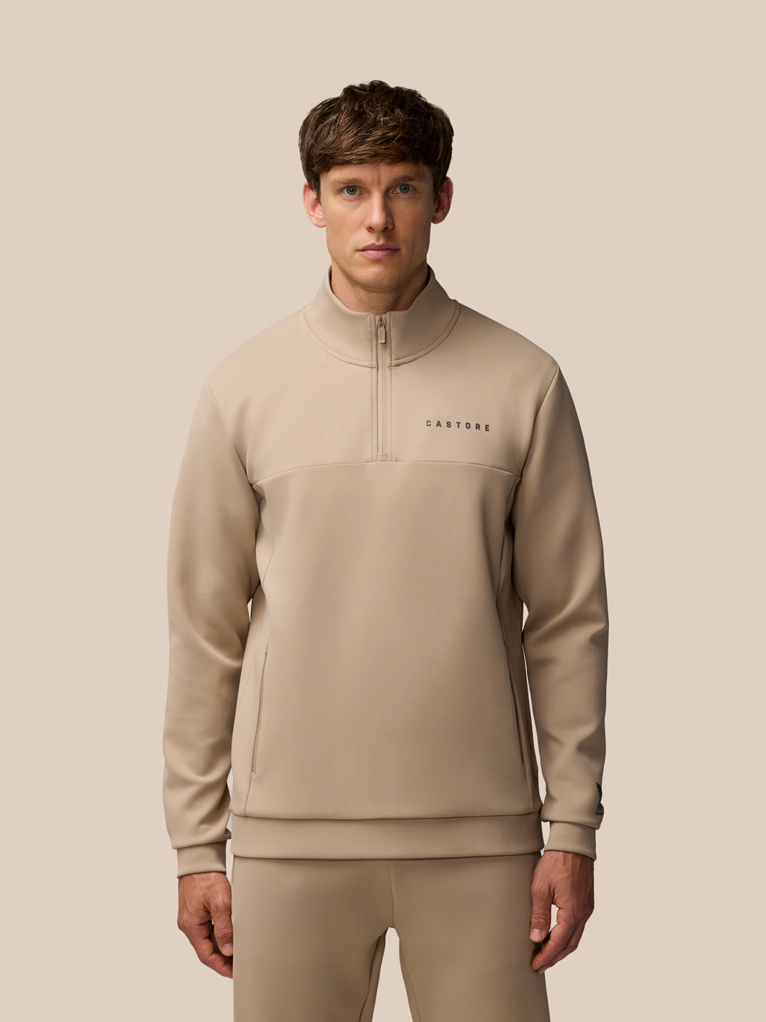 Beige Flex Lifestyle 1/4 zip top with center zip and Castore logo on left chest
