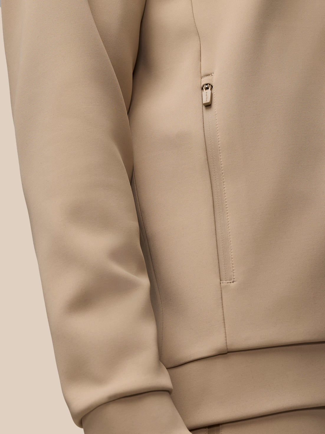 Beige Flex Lifestyle center front quarter zip jacket with visible zip pocket details