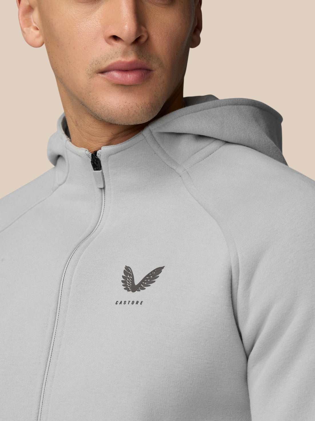 Hoodie with high collar and zip front in grey, small wing logo on chest.