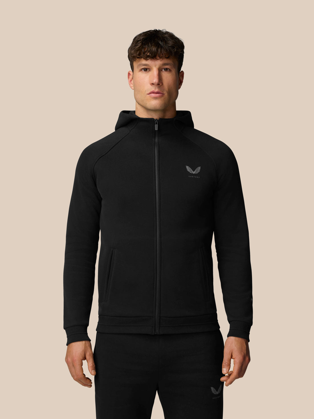 Man wearing black Adapt Fleece Zip-Through Hoodie with zip front and chest logo